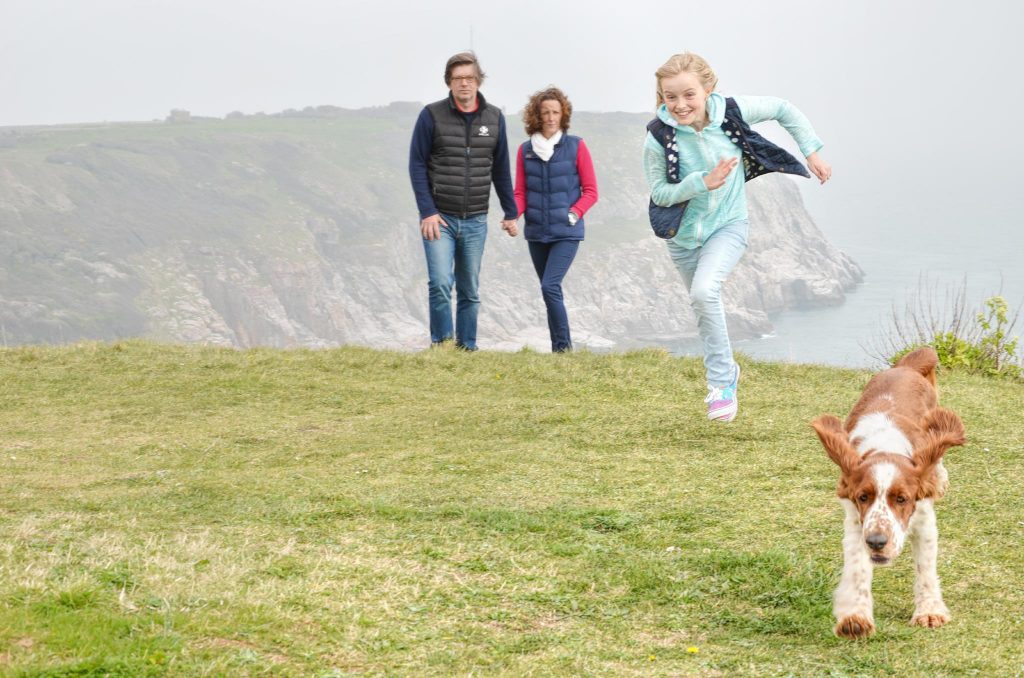 Family with dog on coastal walk in Devon
