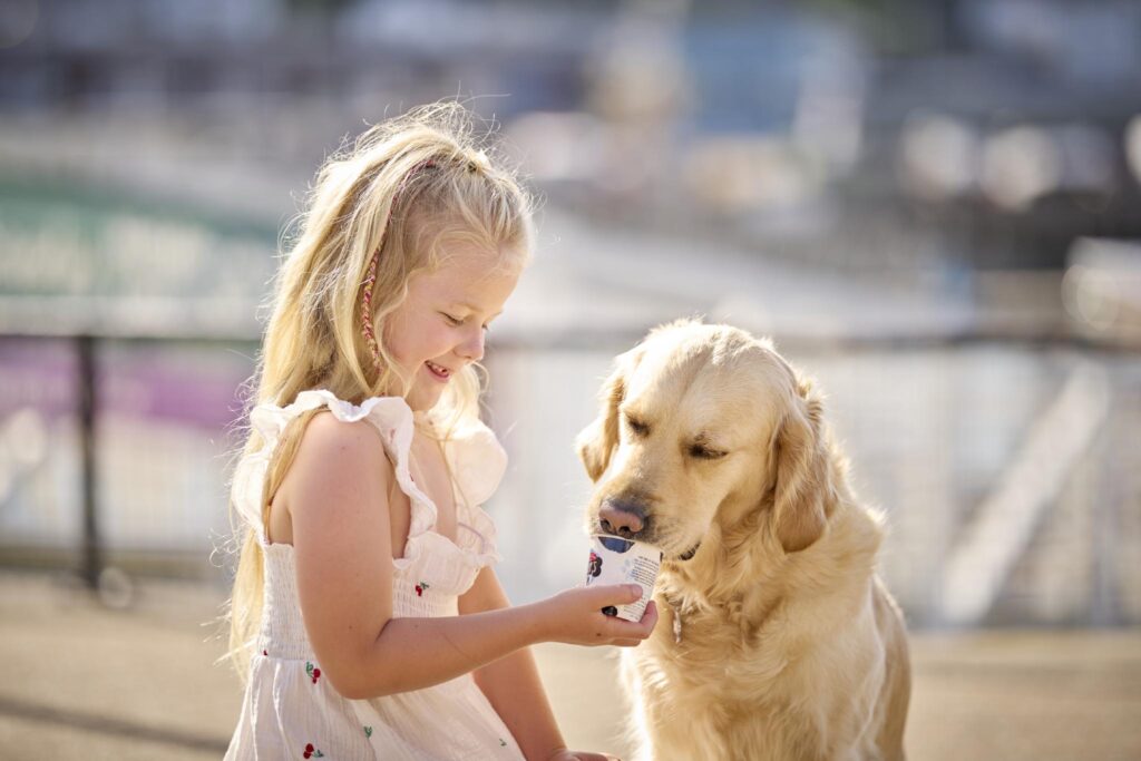 Dog friendly stays in Devon. Girl with dog eating ice cream