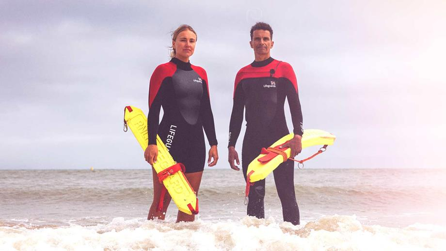 Two RNLI beach lifeguards in the surf